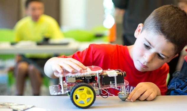 kid playing with coding robot