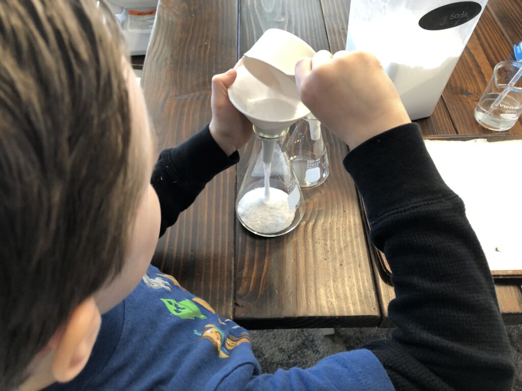 kid filling baking soda container