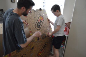 Father helping kids build a fort