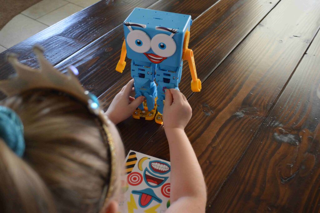 Kids putting stickers on the robot