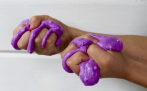 purple slime squeezed in child hand