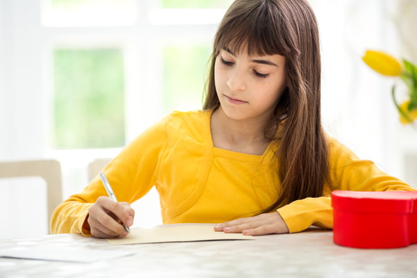 Kid writing a Teacher's Card