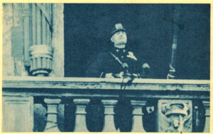 old photo of Benito Mussolini overlooking at balcony.