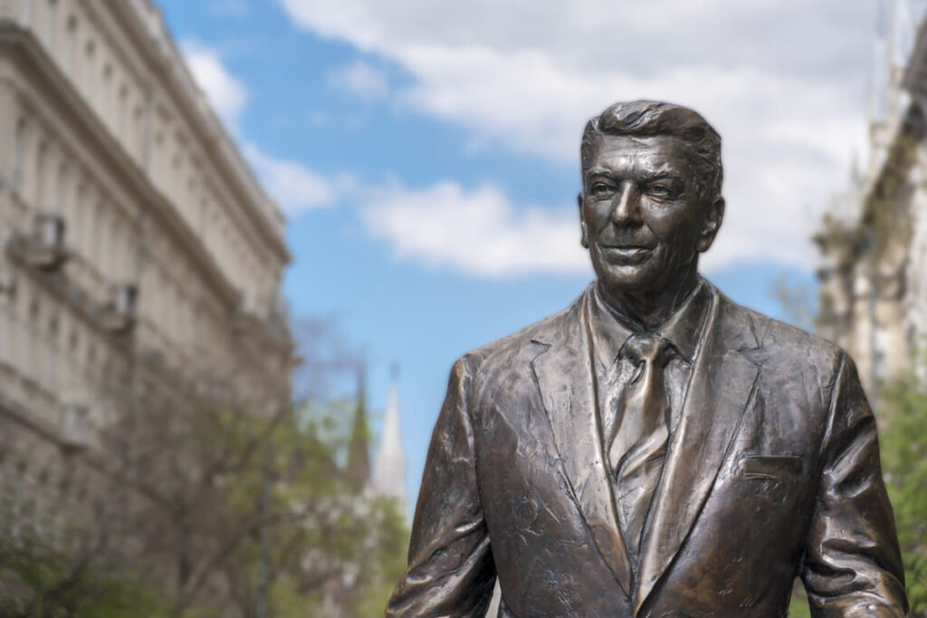 former US president ronald reagan statue on the background of hungarian parliament building