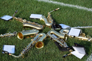 multiple saxophones on a field.
